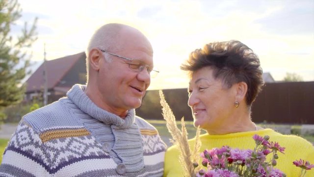 Senior couple is laughing at sunset