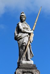 An old sculpture of white marble in the city park.  City park sculpture