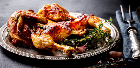 Grilled fried roast Chicken Tabaka with thyme and garlic, in Frying pan on wooden Background.Festive dish.
