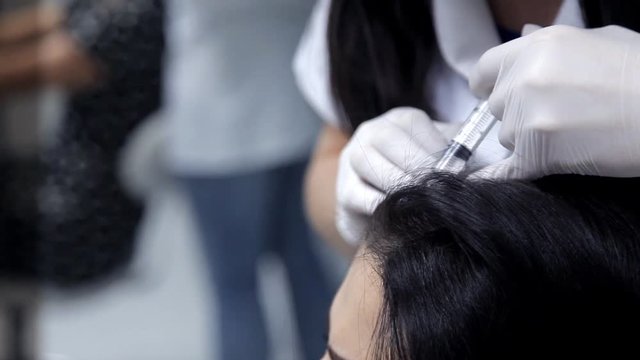 In the beauty salon, the cosmetologist performs the procedure for the mesotherapy of the hair. Close-up