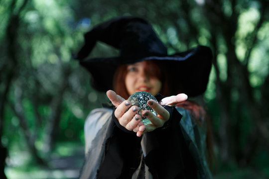 Witch holding magic ball in palms