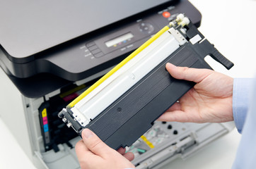 Man replacing toner in laser printer - obrazy, fototapety, plakaty