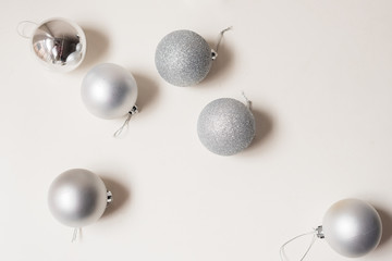 High angle view of silver Christmas tree bauble decorations on white background (selective focus)