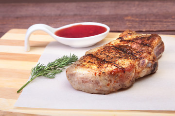grilled pork chop with Cranberry sauce on plate on wooden board