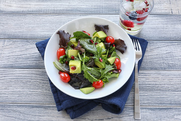 Salad with tomato baby lettuce in white bowl