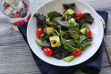 Salad with tomato baby lettuce in white bowl