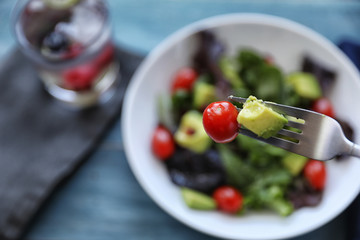 Salad with tomato baby lettuce in white bowl