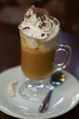 Coffee drink with cocoa powder on wooden table