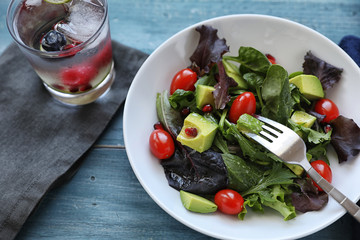 Salad with tomato baby lettuce in white bowl