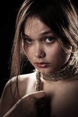 sad young woman with tied neck on black background looking at camera
