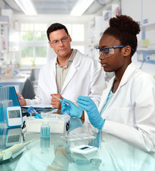 Scientists, Caucasian male and African female, work in laboratory