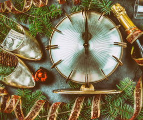 NEW YEAR CELEBRATION. Traditional put money to shoe for have money en New Year. Flat lay composition with vintage clock, shoes with dollars, champagne, Christmas decorations