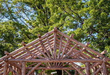 Abstract outdoor wooden canopy roof structure. Roof wood stick design. Outdoor park architecute and design.  Nature design background