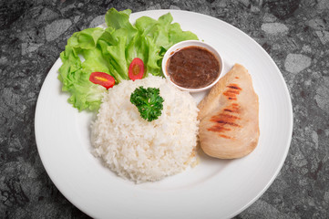 Clean food rice with Chicken Breast with tometo other vegetable and. good for you health in white dish.