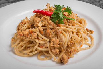 Spicy pork spaghetti on a white plate