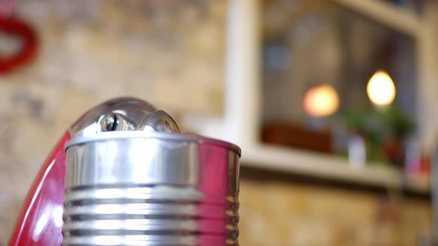 Woman Places A Generic Can On A Can Opener In Her Kitchen