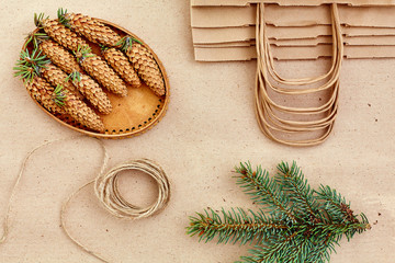 Christmas handmade gifts and everything you need for them. Bags from Kraft paper, fir branches and jute cord. Top view, the concept of simplicity and minimalism