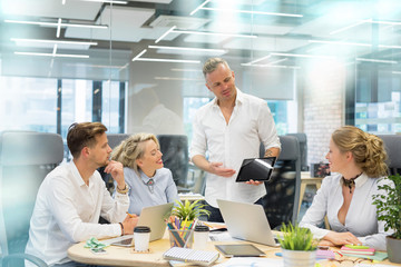 Man presenting something to his co-workers on tablet