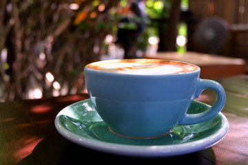 Cup of hot coffee in morning and green nature background .