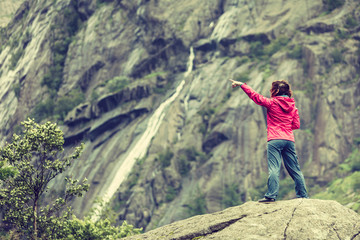 Naklejka premium Woman on mountain rock enjoying beautiful view