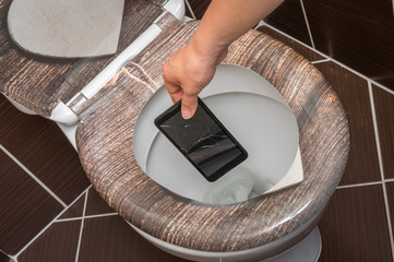 Woman throwing mobile phone in the toilet bowl