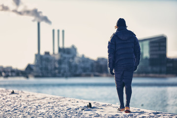 Winter city smog pollution people walking in warm outerwear in cold morning commute. Man runner in...