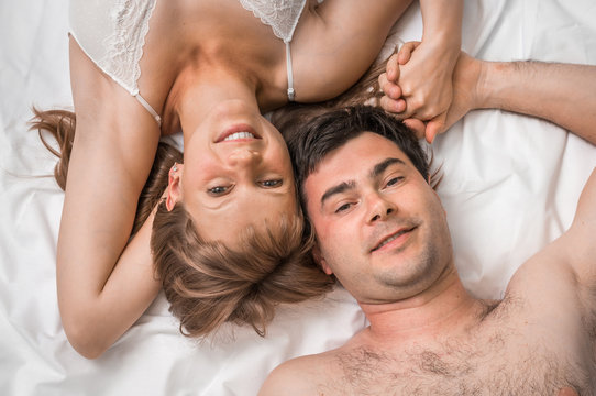 Top view of loving couple lying together in bed
