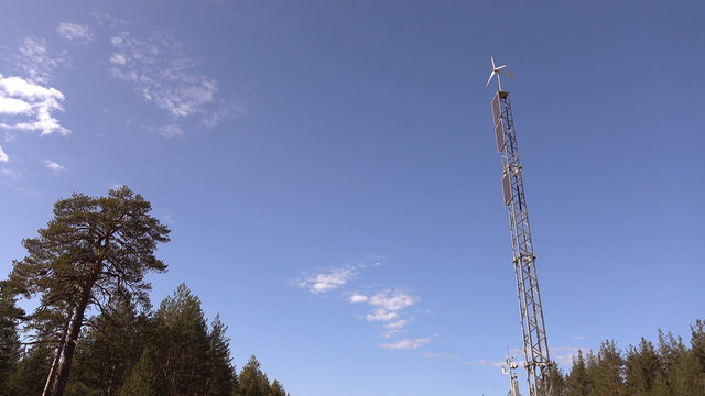 Solar panel and wind turbine on the sky background .