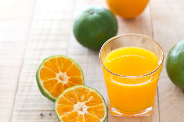 Orange juice glass and oranges fruits on wooden background