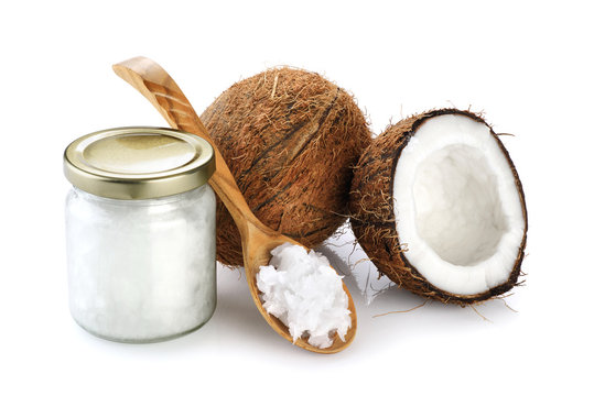 Coconut, glass jar and wooden spoon with coconut oil isolated on white background.