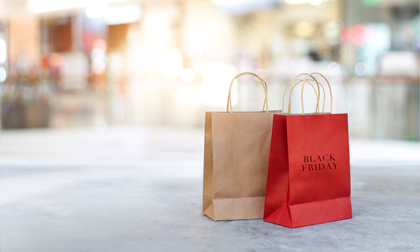 Black Friday shopping bags on the floor outdoors with the mall background