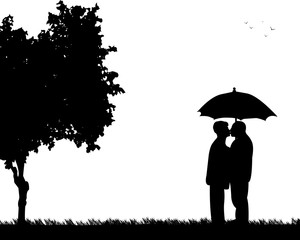 Lovely retired elderly couple standing and kissing under the umbrella in park in autumn or fall, one in the series of similar images silhouette