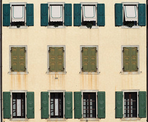 Venetian style urban house  facade with green blinds 