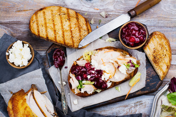Homemade leftover thanksgiving day sandwich with turkey, cranberry sauce, feta cheese and...