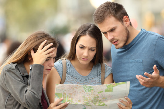 Three lost tourists trying to find a location in a map