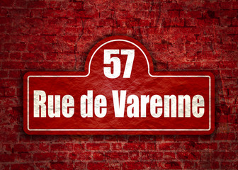Obraz premium Street signs with an inscription in French Varenne street, the building number fifty seven Paris, France. Ancient brick wall grunge texture