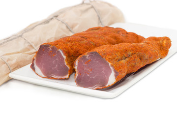 Cured pork tenderloin on a white background
