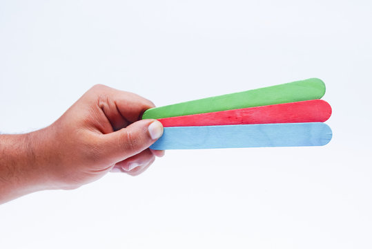 Hand Holding Colorful Ice Cream Stick Over White Background