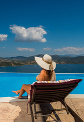 Obraz premium Woman enjoying relaxation in pool and looking at the view
