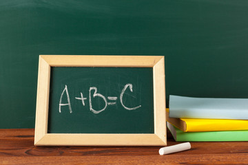 School supplies on a wooden table and blackboard
