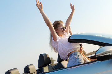 Two attractive young women in a cabriolet car