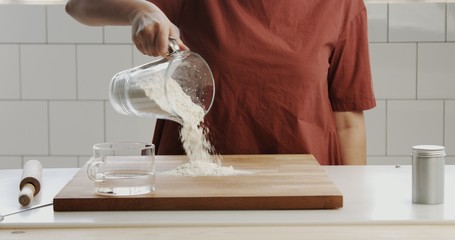 woman nakes dough in sunlight kitchen