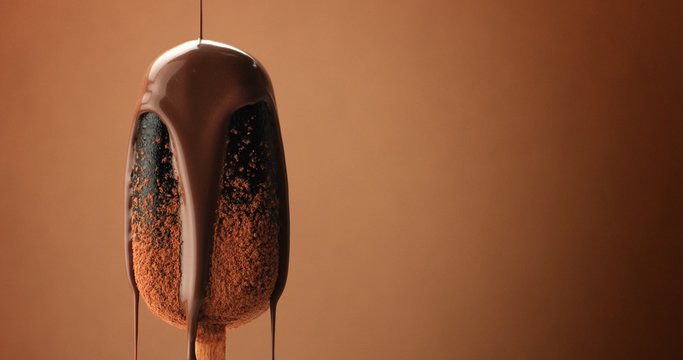 chocolate ice cream on a stick and liquid chocolate covered it. Different chocolate textures. on brown background