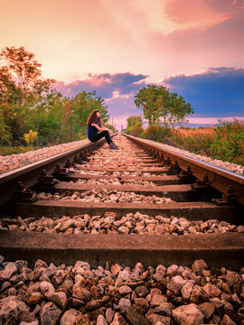 Young Girl Sitting On A Railways In Bulgaria During The Beautiful Sunset