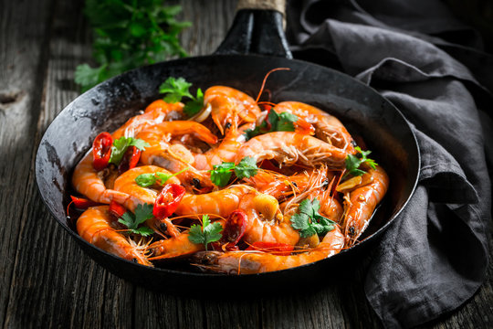 Spicy shrimps on pan with garlic, coriander and peppers