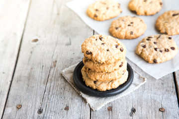 homemade oatmeal cookies with chocolate on an old wooden background
