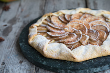 Pie with apples, pears and cinnamon on an old wooden background