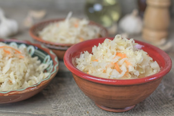 Homemade sauerkraut village. Fermented cabbage. Vegan salad rustic style glass jar or ceramic pottery bowl. Fermented food great for good health. Traditional rustic winter food.