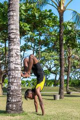 Young yoga man practitioners doing yoga on nature. Asian indian yogis man on the grass in the park. Bali island.