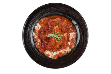 Isolated Top view of Pork rib chops steaks boiled with tomato sauce and cheese served in black round plate.